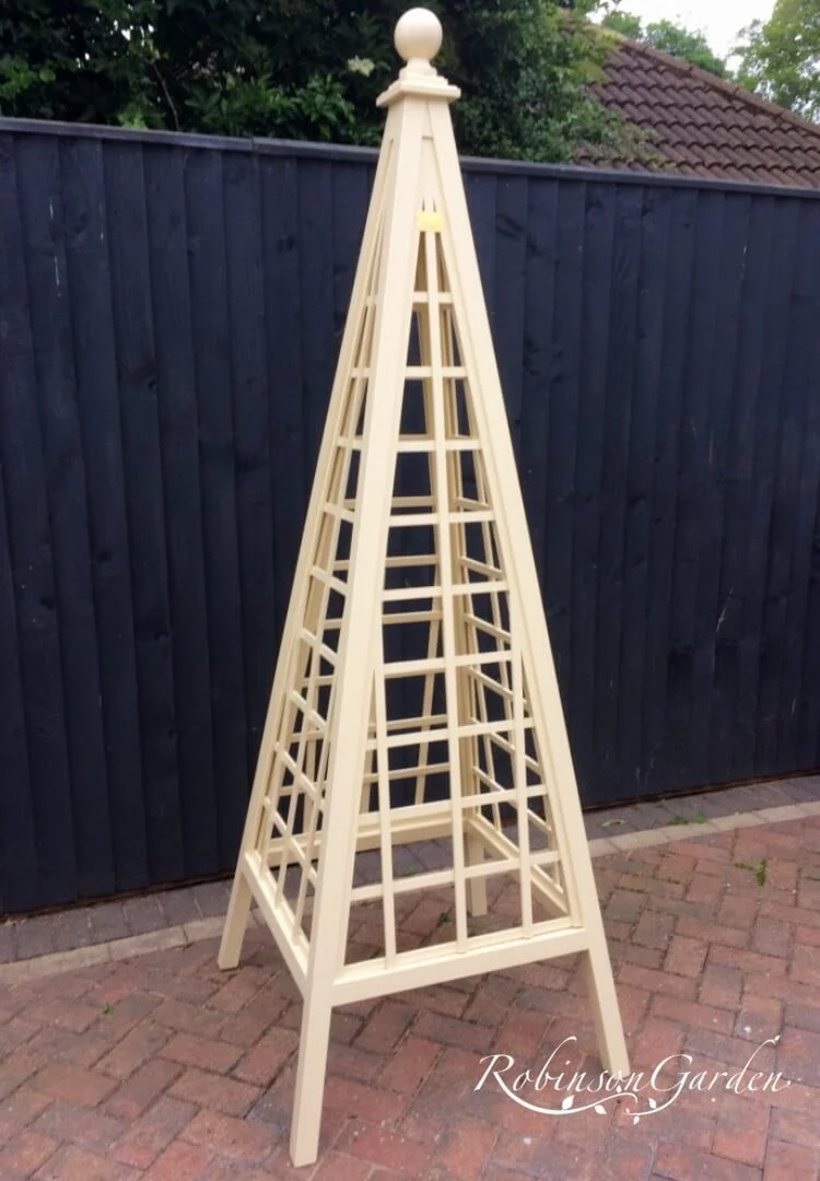 Bespoke wooden garden obelisk design hand painted in Lincolnshire, England, UK using Farrow & Ball exterior eggshell paint. Uniquely crafted using sustainable FSC certified timber / wood. Available in a range of sizes including 5ft (5 foot), 6ft (6 foot) and 7ft (7 foot) as well as trellised design, 8ft design available on request. We sell small garden obelisk, large garden obelisk and tall garden obelisk, The wooden obelisk design is different to Argos, B&M, ALDI, homebase, dobbies, gardman, home bargains, pets at home, B&Q, b & q, amazon, M&S, Robert dyas, rspb, ikea, john lewis, rhs, gumtree, asda, argos, wilkinsons, kingfisher, the garden obelisk company, QVC or any other garden centre. We are an online only store and we are not on the high street. We also have outlet shops across etsy and ebay UK. Not made from metal or copper. Our design plan, dimensions and height are suitable for climbing plants including Roses, sweet peas and is freestanding and a perfect gift for garden lovers. Wooden garden obelisk assembly free and no set up required. Visit out gallery to see all the wooden obelisk images. Wooden obelisk / garden obelisk delivered ready assembled. Perfect bird table for your garden, choice of ball, acorn and unique finial. Designs include Windsor wooden obelisk and Buckingham wooden obelisk. A smart English garden eiffel obelisk. Can be purchased as a set of 3 for your garden.