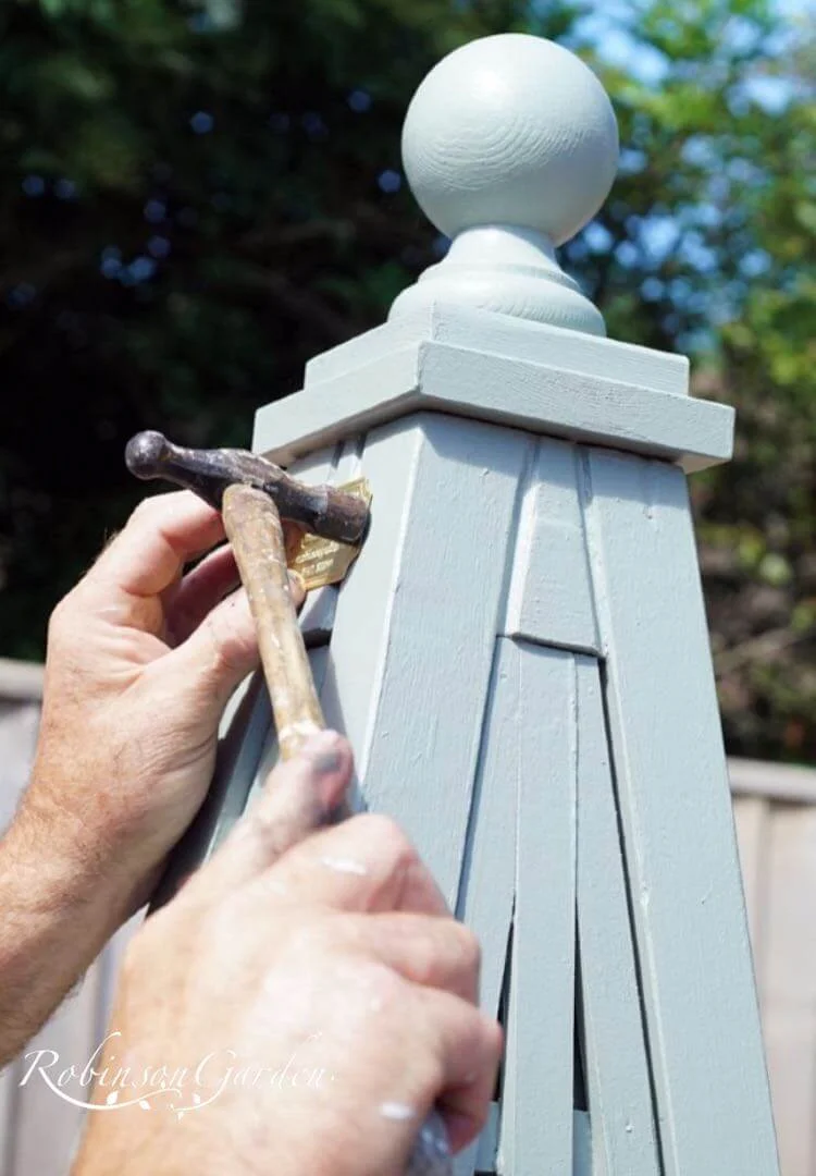 Bespoke wooden garden obelisk design hand painted in Lincolnshire, England, UK using Farrow & Ball exterior eggshell paint. Uniquely crafted using sustainable FSC certified timber / wood. Available in a range of sizes including 5ft (5 foot), 6ft (6 foot) and 7ft (7 foot) as well as trellised design, 8ft design available on request. We sell small garden obelisk, large garden obelisk and tall garden obelisk, The wooden obelisk design is different to Argos, B&M, ALDI, homebase, dobbies, gardman, home bargains, pets at home, B&Q, b & q, amazon, M&S, Robert dyas, rspb, ikea, john lewis, rhs, gumtree, asda, argos, wilkinsons, kingfisher, the garden obelisk company, QVC or any other garden centre. We are an online only store and we are not on the high street. We also have outlet shops across etsy and ebay UK. Not made from metal or copper. Our design plan, dimensions and height are suitable for climbing plants including Roses, sweet peas and is freestanding and a perfect gift for garden lovers. Wooden garden obelisk assembly free and no set up required. Visit out gallery to see all the wooden obelisk images. Wooden obelisk / garden obelisk delivered ready assembled. Perfect bird table for your garden, choice of ball, acorn and unique finial. Designs include Windsor wooden obelisk and Buckingham wooden obelisk. A smart English garden eiffel obelisk. Can be purchased as a set of 3 for your garden.