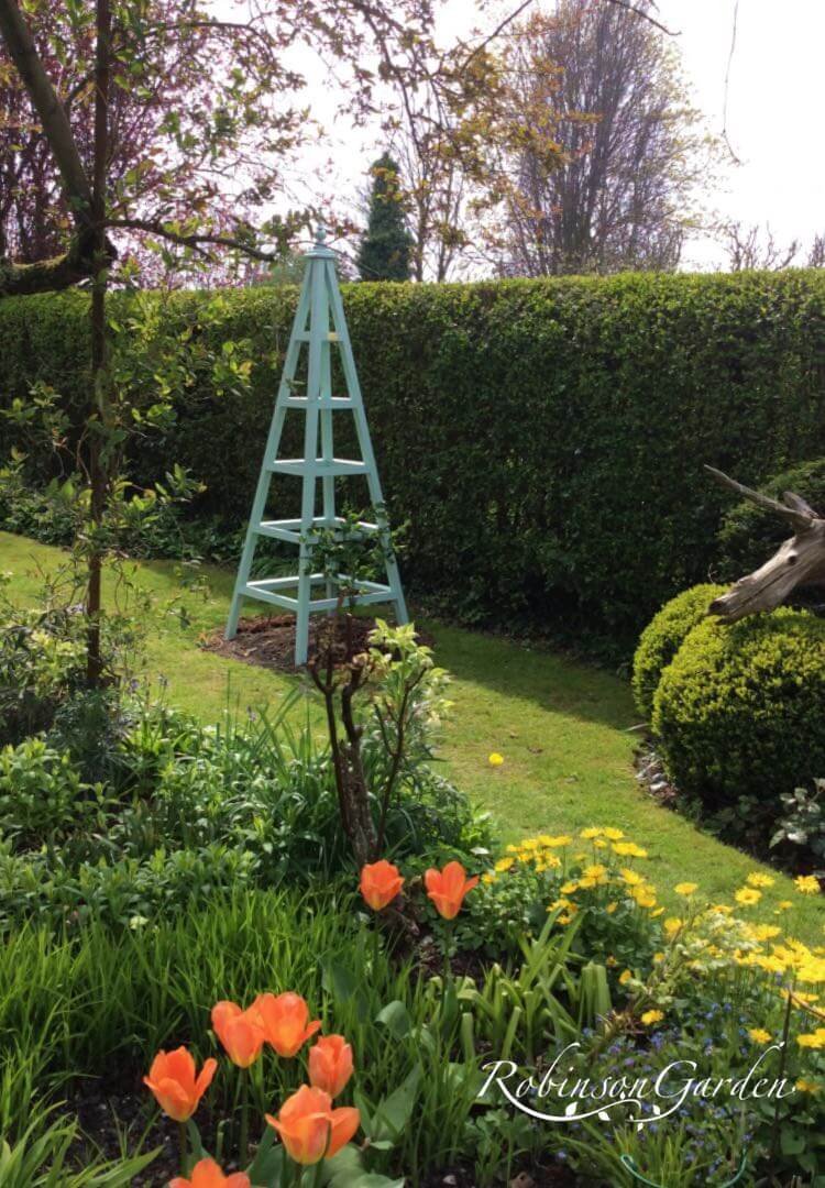 Bespoke wooden garden obelisk design hand painted in Lincolnshire, England, UK using Farrow & Ball exterior eggshell paint. Uniquely crafted using sustainable FSC certified timber / wood. Available in a range of sizes including 5ft (5 foot), 6ft (6 foot) and 7ft (7 foot) as well as trellised design, 8ft design available on request. We sell small garden obelisk, large garden obelisk and tall garden obelisk, The wooden obelisk design is different to Argos, B&M, ALDI, homebase, dobbies, gardman, home bargains, pets at home, B&Q, b & q, amazon, M&S, Robert dyas, rspb, ikea, john lewis, rhs, gumtree, asda, argos, wilkinsons, kingfisher, the garden obelisk company, QVC or any other garden centre. We are an online only store and we are not on the high street. We also have outlet shops across etsy and ebay UK. Not made from metal or copper. Our design plan, dimensions and height are suitable for climbing plants including Roses, sweet peas and is freestanding and a perfect gift for garden lovers. Wooden garden obelisk assembly free and no set up required. Visit out gallery to see all the wooden obelisk images. Wooden obelisk / garden obelisk delivered ready assembled. Perfect bird table for your garden, choice of ball, acorn and unique finial. Designs include Windsor wooden obelisk and Buckingham wooden obelisk. A smart English garden eiffel obelisk. Can be purchased as a set of 3 for your garden.